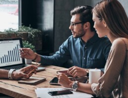 Business professionals. Group of young confident business people analyzing data using computer while spending time in the office